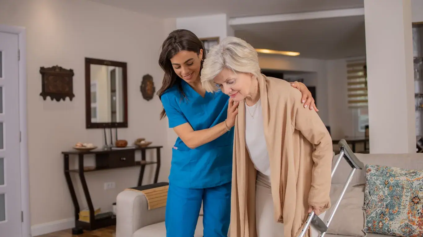 A Samnells carer helping an elderly woman walk at home